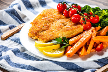 Fried pork chop, French fries and vegetable salad
