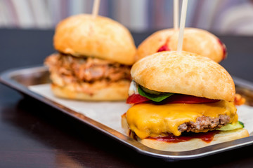 Close up three tasty burgers with different filling served on tray