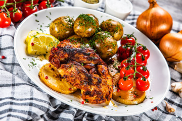 Grilled chicken fillet and vegetables on white plate