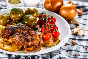 Grilled chicken fillet and vegetables on white plate