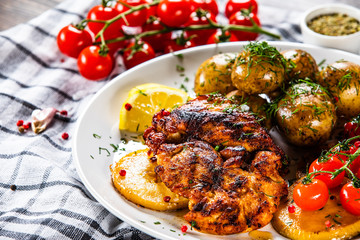 Grilled chicken fillet and vegetables on white plate