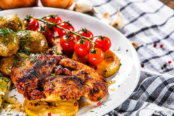 Grilled chicken fillet and vegetables on white plate