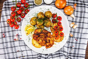 Grilled chicken fillet and vegetables on white plate