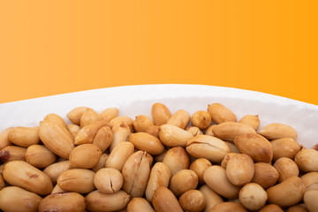 Roasted peeled peanuts in white bowl, peanut concept photo