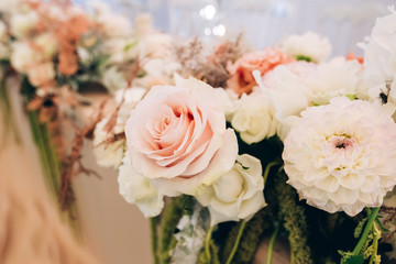Gorgeous luxury wedding table arrangement, floral centerpiece close up. The table is served with cutlery, crockery and covered with a tablecloth. Wedding party decoration with pink and white flowers.