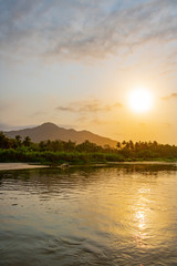 Fototapeta na wymiar beautiful sunset over a tropical landscape with river and rainforest