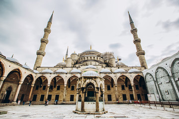 Fototapeta na wymiar Fatih Mosque or Conqueror Mosque in Istanbul, Turkey. Blue Mosque photographed at a wide angle. Islamic architecture on a sunny summer day. Panoramic view of the courtyard of the mosque.