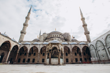 Fototapeta na wymiar Fatih Mosque or Conqueror Mosque in Istanbul, Turkey. Blue Mosque photographed at a wide angle. Islamic architecture on a sunny summer day. Panoramic view of the courtyard of the mosque.