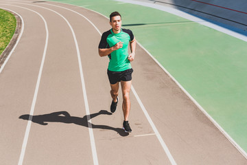 full length view of mixed race sportsman running at stadium