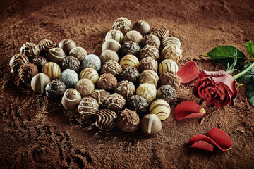 Heart of artisan chocolates next to roses
