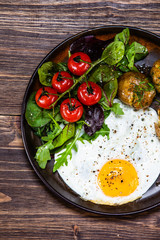 Fried egg, boiled potatoes and vegetables