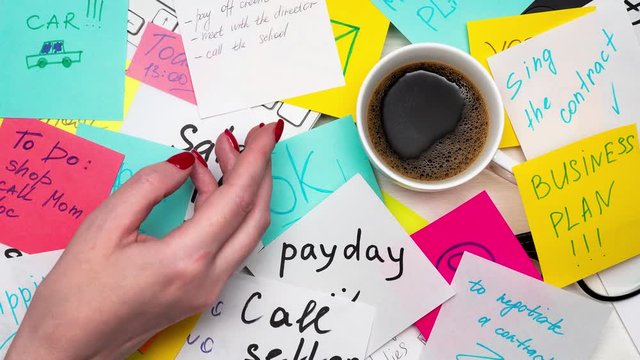 Hard day at work concept. Stopmotion of workplace with notes and todo lists. Person overloaded with work.