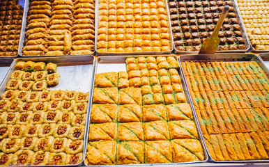 A wide range of oriental sweets, baklava, Turkish delight with almonds, cashews and pistachios on plates. photo of the eastern market. Showcase Grand Bazaar.