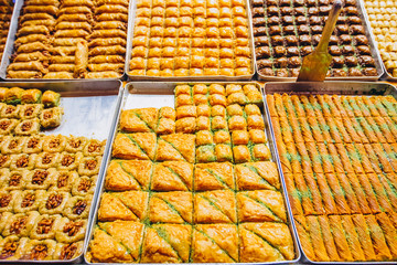 A wide range of oriental sweets, baklava, Turkish delight with almonds, cashews and pistachios on plates. photo of the eastern market. Showcase Grand Bazaar.