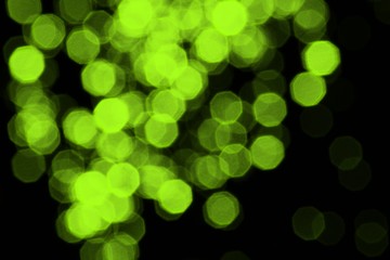 lime bokeh effect of brilliant highlights on black texture - beautiful abstract photo background