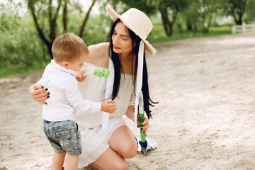 Family in a summer park. Mother in a white dress. Cute little boy