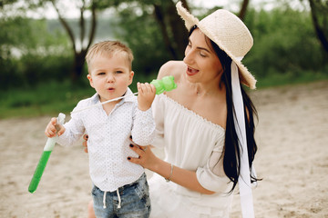 Family in a summer park. Mother in a white dress. Cute little boy