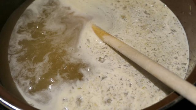 Cooking elder beery flower head jam confiture in a pot.