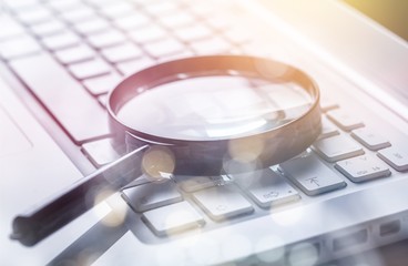 Business analytics and statistics concept, Magnifying glass on keyboard