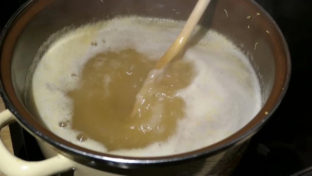 Cooking elder beery flower head jam confiture in a pot.
