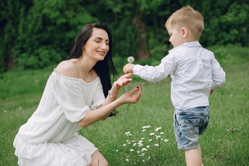 Family in a summer park. Mother in a white dress. Cute little boy