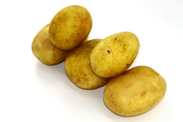 On a white background diagonally lie five potatoes clean of different sizes