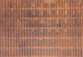 Close up full frame view of a section of a rusty metal grate covering a hole on a street during construction