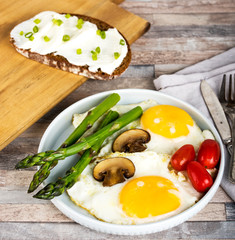 Breakfast. Scrambled eggs, asparagus, champignons, cherry tomatoes, sandwich