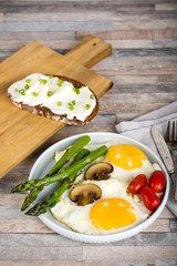 Breakfast. Scrambled eggs, asparagus, champignons, cherry tomatoes, sandwich