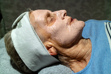 Berkshire, UK. June 2019. An elderly woman's face during facial beauty treatment.