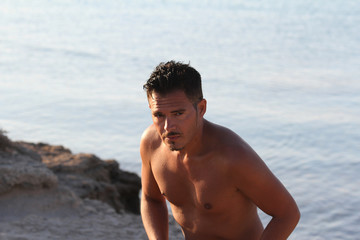 Handsome man with swimsuit are enjoying on the beach at sunset. Apulia, Salento, Italy
