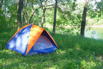 Tourist tent on the background of forest and river