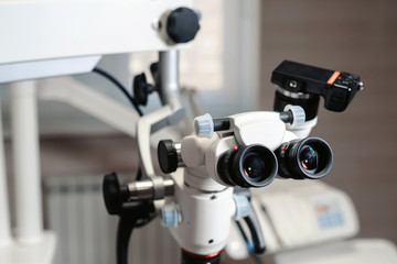 Dental binocular microscope on the background of modern dentistry. Medical equipment. operating microscope. with rotary double dental microscope white cabinet working room
