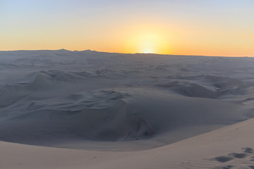 sunset at huacachina desert oasis in peru