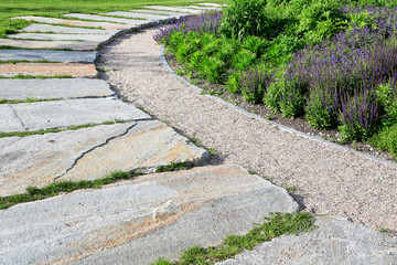 Natursteine im Materialmix zur Gehweggestaltung mit Pflanzen im modernen Gartenbau und Landschaftsbau	