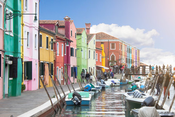 Fototapeta na wymiar Beautiful colorful street with multi colored facades of residential painted buildings along the embankment of the canal with moored motor boats. Sunny summer bright day. Traditional architecture style