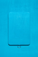 Blue wooden cutting board on a blue background with scratches