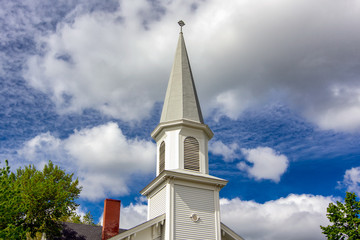 Traditional White Church and Steeple with Blue Sky and Puffy Clouds