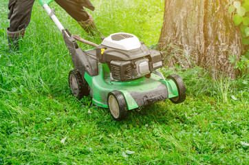Worker mows the grass on the lawn in the park gasoline lawn mower