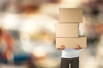 Man with cardboard boxes on bokeh background