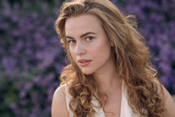 Fototapeta premium Portrait of young positive woman with curly hair. Close up looking to camera girl.