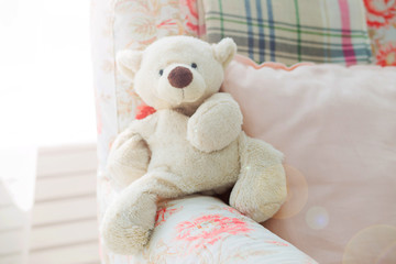 toy teddy bear sits in an armchair
