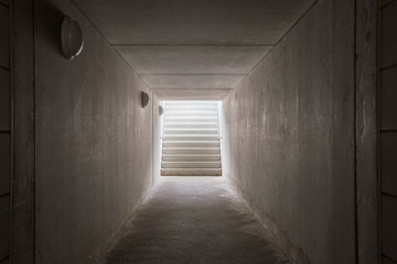 Underground passage with stairs in the glowing end