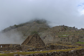 fog over machu picchu inca ruins in peru