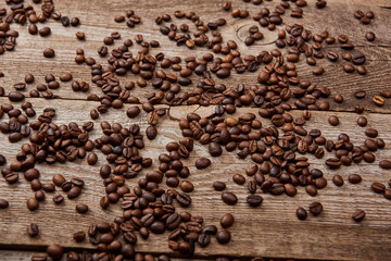 wooden rustic table with scattered roasted coffee beans