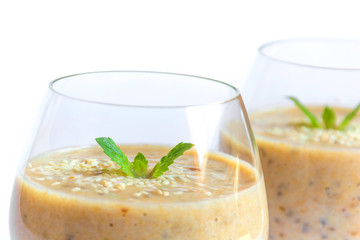 Vegetarian healthy banana smoothie in glass with mint isolated on white background