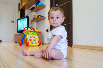 cute seven months old baby boy playing with educational toys on the floor