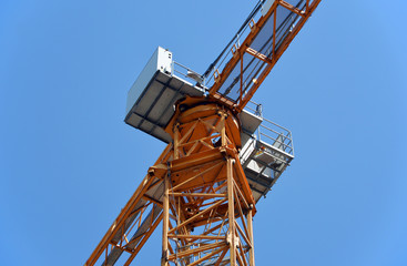 Construction tower crane against the blue sky. Fragment