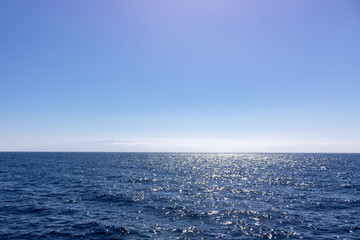 Naklejka na ściany i meble Seascape with sea horizon and almost clear deep blue sky