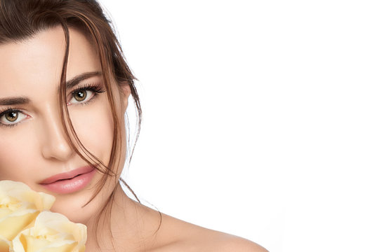 Beautiful young woman with yellow roses. Skincare and healthy cosmetology concept